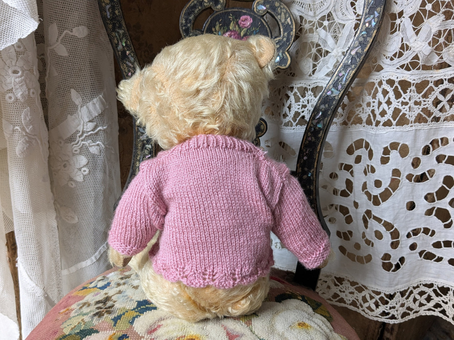 Vintage teddy bear in pink cardigan