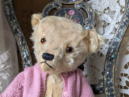 Vintage teddy bear in pink cardigan